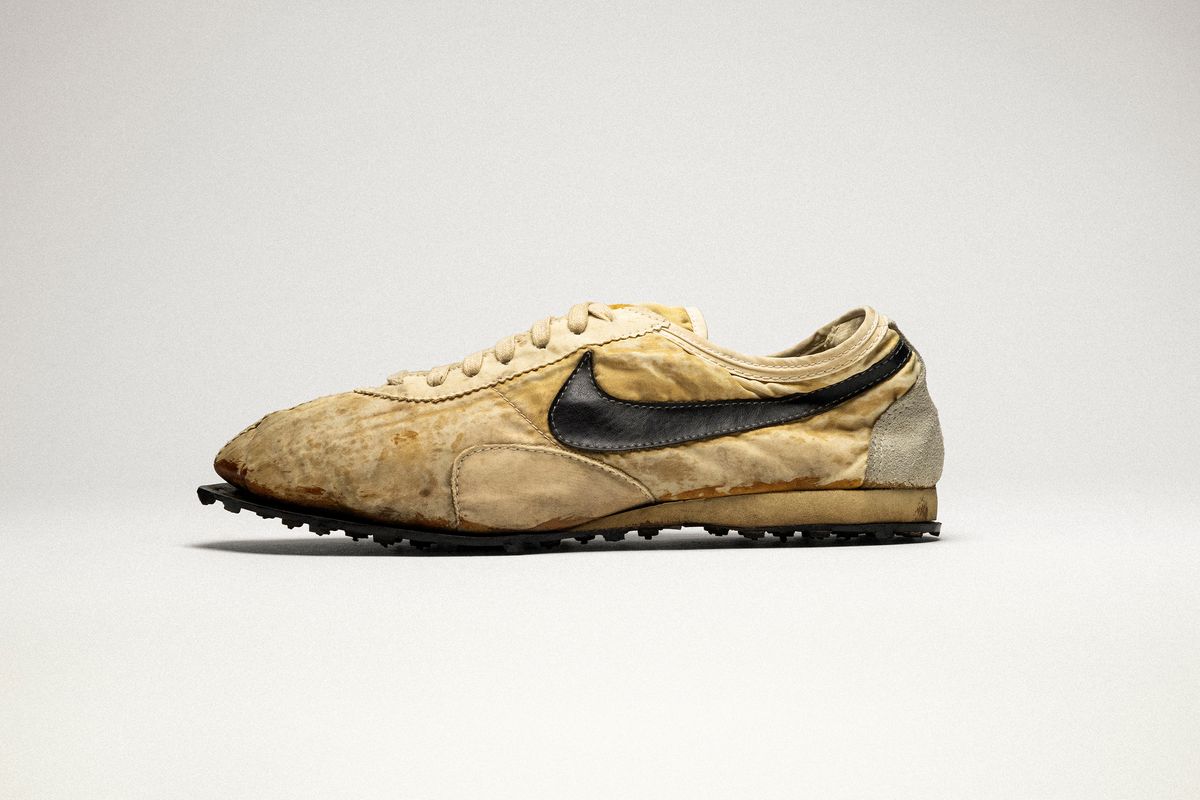 A worn, dirt-stained original 1972 Nike Moon Shoe, tan canvas upper with a black swoosh, hand-cobbled waffle-soled sneaker