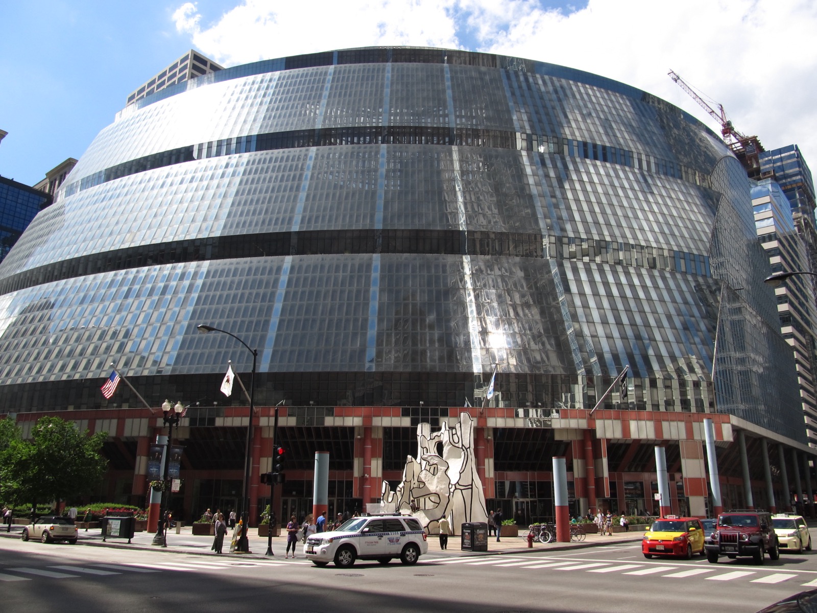 Exterior view of the James R. Thompson Center's curved, multicolored glass and steel facade rising above a Chicago Loop street