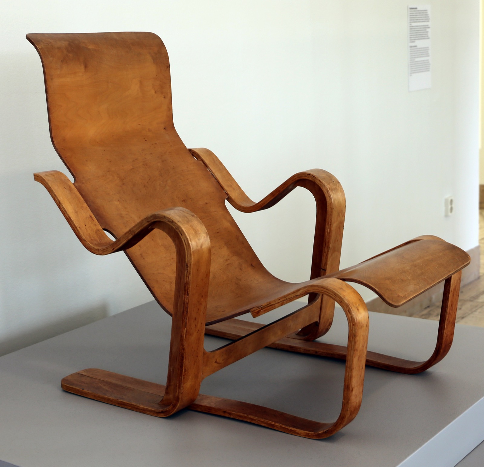 Marcel Breuer's Isokon Long Chair, a continuous curved plywood lounge chair, photographed in a museum collection