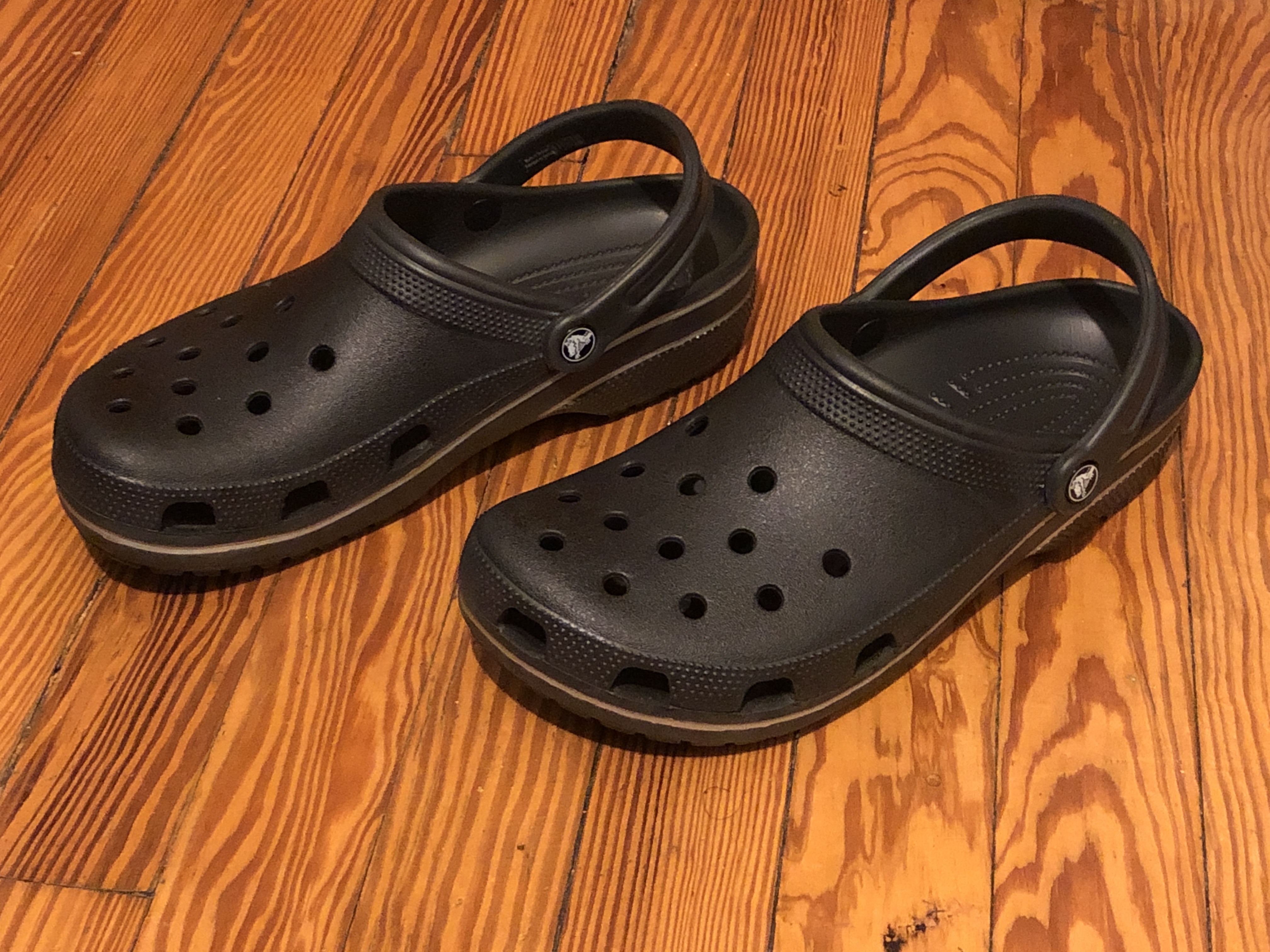 A pair of bright green Crocs synthetic clogs with ventilation holes