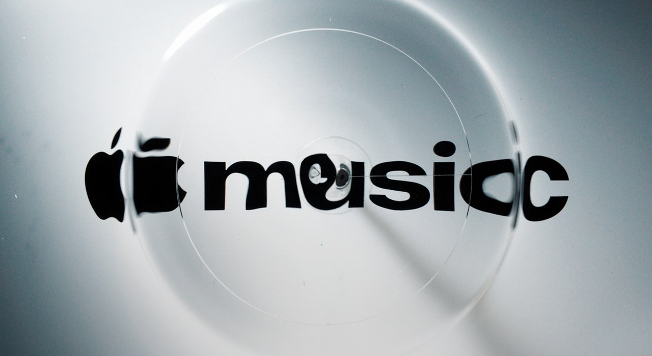 The new Apple Music wordmark, the Apple symbol beside the word music in heavy black lowercase, distorted by ripples in liquid
