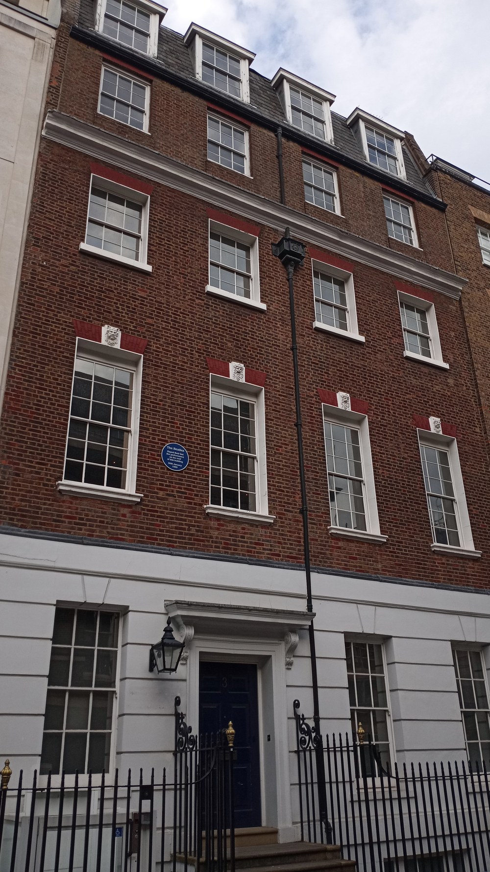 The brick facade of 3 Savile Row in London, with a blue plaque between the first-floor windows
