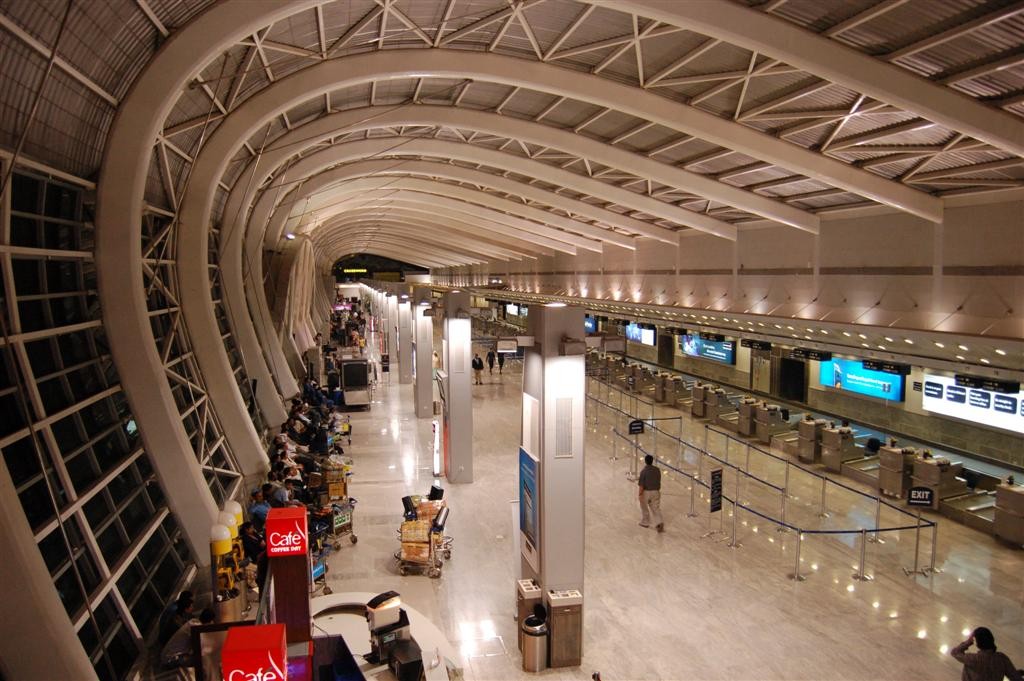 Inside Terminal 1B at Mumbai airport in 2007: a long departures hall under curved white roof ribs, check-in counters on the right